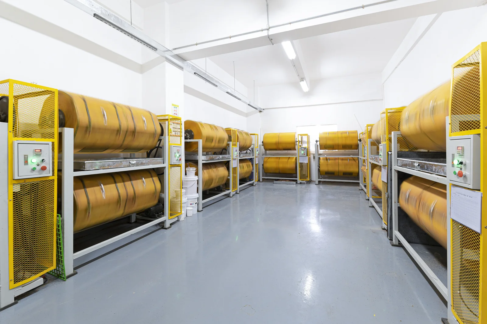 Rows of rotary drums used for batch jewelry finishing